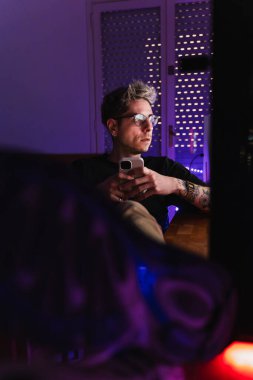 Dijital yaratıcı odasında telefonla sohbet ederken bilgisayar ekranına bakıyor..