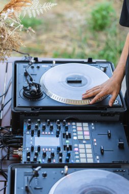 Karıştırma konsolunun döner tablosunu çeviren DJ 'in yakın plan ayrıntıları.