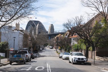 Arka planda Liman Köprüsü olan boş Sydney banliyö caddesi.