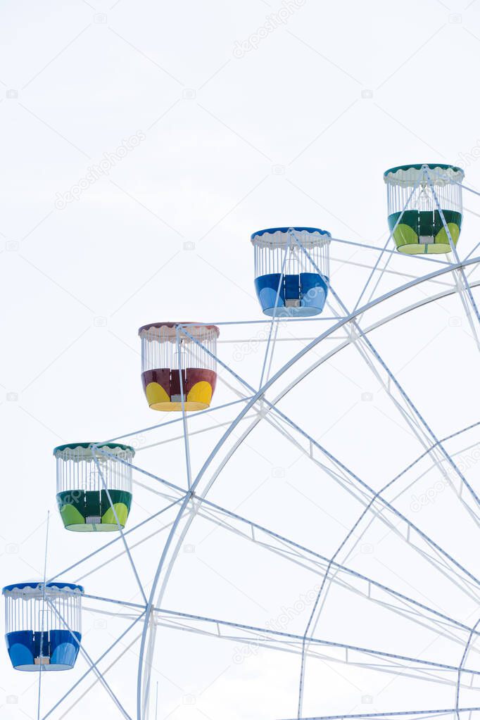 Background of a colorful ferris wheel spinning in a clear sky.