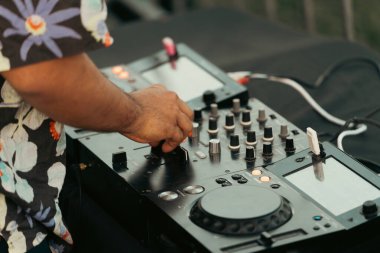 Hawaii tişörtlü bir DJ 'in yaz partisinde mikser çalması..