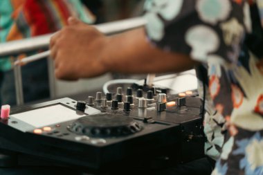 DJ dışarıda bir partide mikserle oynarken sigara içiyor..