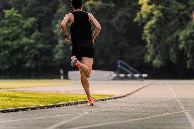 Açık havada koşarken arkadan görülen bir sporcu. Boşluğu kopyala.