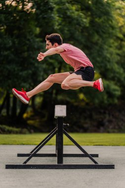 Steeplechase runner training on the athletics track. Vertical. clipart