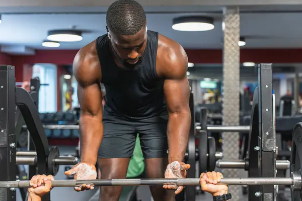 stock image Black fitness trainer helping another man at the gym with the barbell.