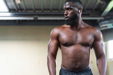 Spor salonunda hacim aşamasında olan siyah erkek vücut geliştirici..