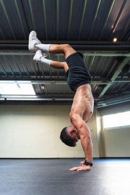 Atletik vücutlu genç Latin bir adam amuda kalkıyor..