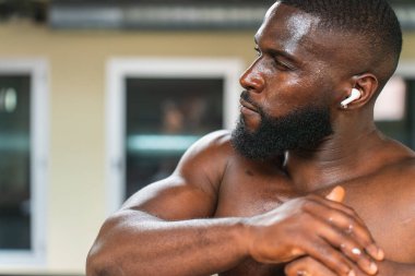 Spor merkezinde kaslarını esneten siyah bir sporcu..