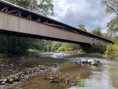The Academia Pomeroy Covered Bridge at 278-foot-long (85 m)  is the longest remaining covered bridge in Pennsylvania. Listed on the National Register of Historic Places in 1979.  single-lane, double-span wooden covered bridge. Rural scene in fall clipart