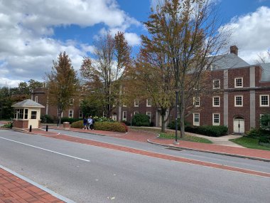 Eyalet Üniversitesi, Pennsylvania, ABD, 7 Ekim 2023 Pennsylvania Eyalet Üniversitesi kampüsünde bulutlu bir günde ağaçların arkasındaki kırmızı tuğladan bina. Penn State 'de Sonbahar.