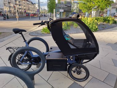 Viyana, Avusturya, 2 Mayıs 2024: Chike tarafından kargo kutularıyla elektrikli bisiklet ve Floridsdorf hastanesinin önünde park edilmiş çocuk kulübesi bisikletleri. Çevre dostu hareketlilik.