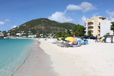 Philippsburg, Sint Maarten, Netherlands - November 26, 2016: Great Bay Beach at caribbean Island of St. Maarten near Cruise port. White Sand, colorful parasols, sun beds. Vacation on stunning tropical Island. clipart