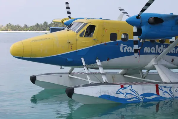 stock image Kuredu, Maldives, December 9, 2014: Close up of cockpit and front of seaplane by Trans Maldivian Airways. Tropical Island in background. Turboprop, blue yellow colored. Twin otter seaplane. De Havilland Canada DHC-6-300 