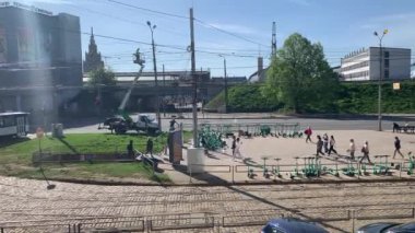 Riga, Letonya, 3 Mayıs 2024 Riga şehir merkezindeki işlek cadde. Bir sürü yaya bir alt geçide doğru gidiyor. Toplu taşıma şirketi Rigas Satiksme tarafından işletilen tramvaylar yoldan geçen yolcularla dolu..