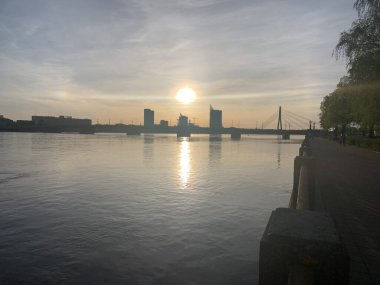Riga, Letonya, 2 Mayıs 2024: Vansu Köprüsü 'nde (Letonca: Vansu tilts) gün batımı Riga ufuk çizgisiyle Daugava nehrinde. Sovyet döneminde inşa edilmiş, sonra Gorky Köprüsü denmiş..