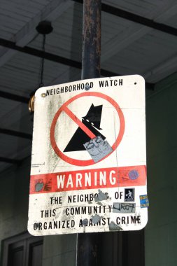New Orleans, Louisiana, ABD, 28 Ekim 2017, New Orleans mahalle devriyesi hakkında bilgi veriyor. Uyarı yazıyor. Bu topluluğun mahallesi suça karşı örgütlenmiştir. Üstü çizilmiş bir hırsız ve farklı çıkartmalar olan bir piktogram..