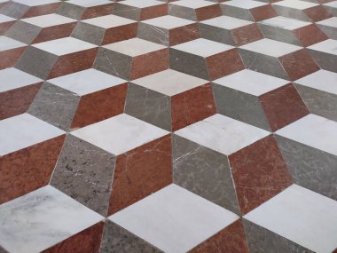 Abstract 3D background, optical illusion or deception. Diamond shaped stones. Subjective perception of bands, zigzag lines, cubes. White, red, gray marble floor of the Admont Library, Styria, Austria clipart