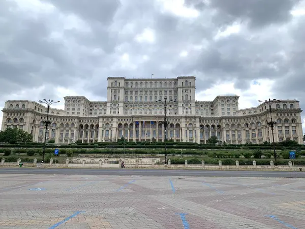 stock image Bucharest, Romania, July 3, 2024: Palace of the Parliament (Romanian: Palatul Parlamentului). Seat of Parliament of Romania. One of heaviest buildings in the world. Impressive clouds, gray sky.