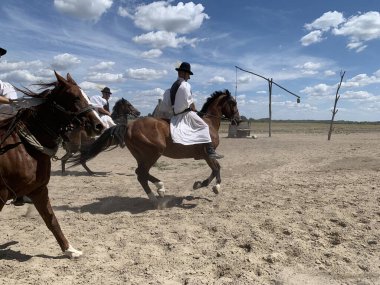 Bugac, Macaristan, 7 Ağustos 2024: Macaristan 'da Macar Puszta' da binicilik gösterisinde at biniciliği yapan at yarışçısı Csiks 'in yakın çekimi. Arkaplanda iyi çiz.