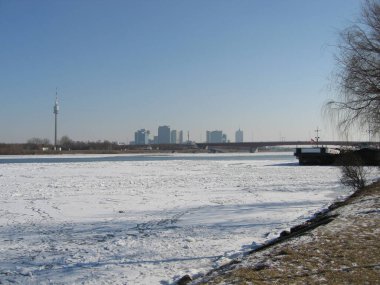 Viyana, Avusturya, 6 Şubat 2006: Tuna Kulesi 'nin panoramik manzarası ve Tuna Nehri üzerinde donarak Viyana Uluslararası Merkezi ve UNO-City' nin ufuk çizgisi. 2000 'lerin güneşli ve serin kışı.
