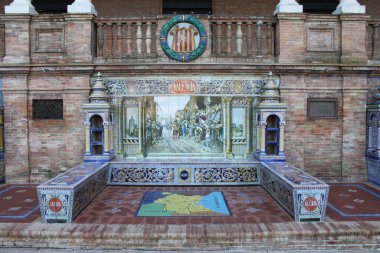 Sevilla, İspanya - 10 Kasım 2010: İspanya Meydanı 'nın kıvrımlı dış kısmı boyunca uzanan bank ve fayans mozaikleriyle Valencia eyaletini temsil eden oyuk. Frescos, 52 İspanyol vilayetini tasvir ediyor..