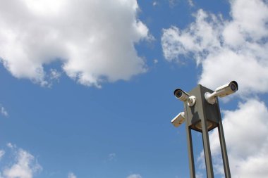 Szolnok, Macaristan 6 Ağustos 2024: Çinli Hikvision şirketi tarafından bulutlu mavi gökyüzüne karşı üretilen güvenlik kameraları. 360 derece gözlem. Boşluğu Kopyala