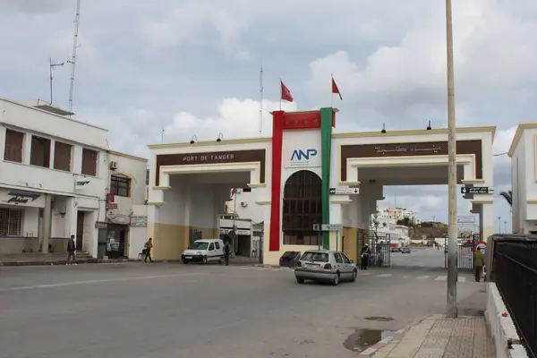 Tanger, Fas - 8 Kasım 2010: Gündüz vakti Tanger Limanı 'na giriş ve çıkış kapıları meşgul. Geçidi koruyan polis memuru. Geçen araçlar.