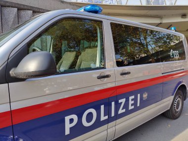 Viyana, Avusturya - 7 Kasım 2024: Avusturya polis minibüsünün yan görüntüsü. Etiketli Polis. Acil durum numarası 133. Renkli camlar. Arabanın çatısında mavi ışıklar. Karlsplatz Karakolu 'nun önüne park ettim..
