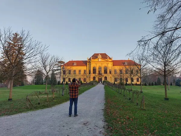 Eckarsau, Avusturya, 9 Kasım 2024: Eski imparatorluk konutu Habsburg 'un fotoğrafını çeken adam: Schloss Eckartsau (Şato Eckartsau), Aşağı Avusturya. Sonbaharın son ışıklarıyla aydınlandı..