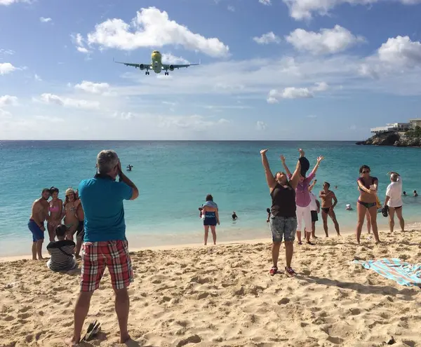 Sint Maarten, Hollanda, 26 Kasım 2016: Yoğun Maho plajında tezahürat kalabalığı. Uçak, Prenses Juliana Uluslararası Havalimanı 'na alçak irtifa üstgeçişi ile yaklaşıyor. İnsanlar poz veriyor, fotoğraf çekiyor.