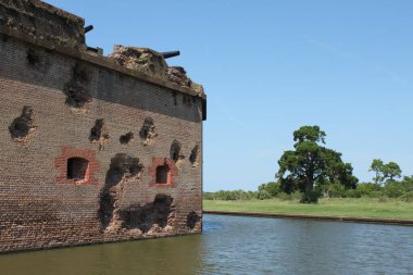 Savannah, Gürcistan, ABD - 23 Eylül 2024: Birlik topçu mermilerinden hasar gören devasa tuğla duvar. Kraterler güney ve güneydoğu duvarlarını kısmen onardılar. Fort Pulaski 'de su dolu hendek