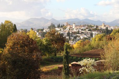 Meşhur Alhambra sarayından Granada şehrine manzara. Sonbaharda resim gibi İspanyol manzarası. Geleneksel evleri olan şehir. Uzakta Sierra Nevada dağları.