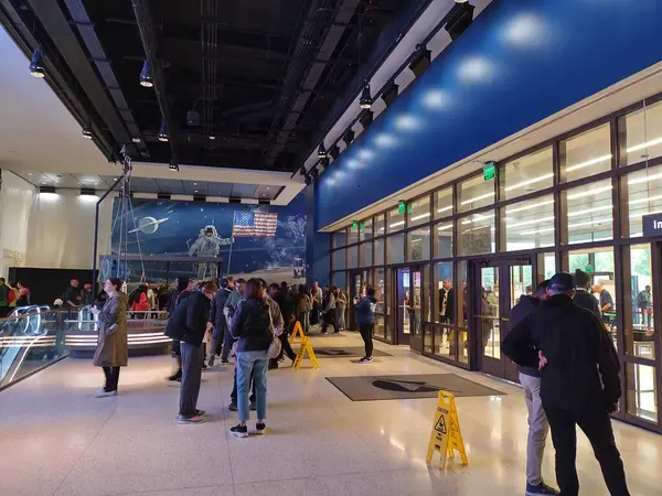 Washington D.C., ABD - 1 Ekim 2024: Smithsonian Ulusal Hava ve Uzay Müzesi giriş alanı. Uzay giysili astronot ve Amerikan bayrağı, Güney Lobisinde geçit yapan ziyaretçileri karşılıyor.. 