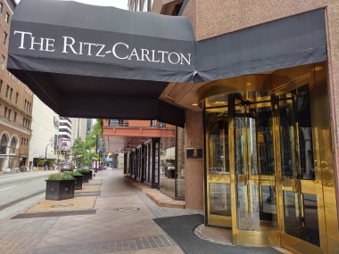 Atlanta, GA, ABD - 28 Eylül 2024: Atlanta 'daki Ritz Carlton Oteli' nin yan görüntüsü döner kapılı ve siyah kanopili. Sonbaharda kasvetli bir günde boş kaldırım.