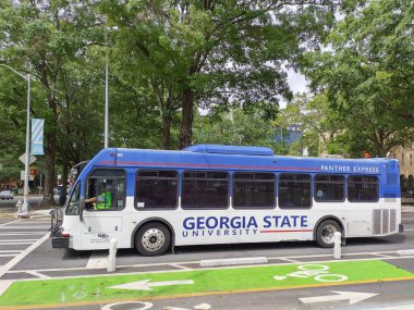 Atlanta, GA, US, September 28, 2024: Georgia State bus driving. Green marked bike path in Atlanta. Georgia State Universitys transit fleet, Panther Express, provides service. Shuttle ride to campus. clipart