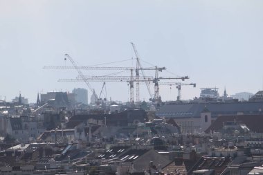 Vienna, Austria - January 01, 2025: Roofs of Vienna's city center and massive construction cranes. clipart