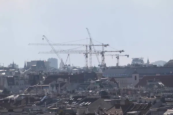 Viyana, Avusturya - 01 Ocak 2025: Viyana şehir merkezinin çatıları ve devasa inşaat vinçleri.