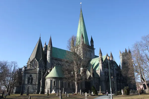 Trondheim, Trondelag, Norveç - 11 Nisan 2019: Trondheim 'ın Nidaros Katedrali (eski adı: Nidaros). Ulusal tapınak olarak kabul edilir. Eski mezarlığın antik mezar taşları. Baharın erken saatlerinde güneşli bir gün