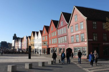 Bergen, Vestland, Norveç - 8 Nisan 2019: Bergen 'in Bryggen ilçesindeki tarihi binalar. Renkli evler UNESCO Dünya Mirası Alanının bir parçası. Baharın erken saatlerinde mavi gökyüzü güneşli..