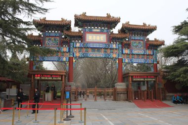 Dongcheng, Beijing, China - March 22, 2017: Red carpets to impressive entrance gate to Yonghe Temple with staff and security personal waiting to assist visitors. clipart