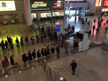 Shanghai, China - March 13, 2017: Queues of travellers at security area at Shanghai Hongqiao Railway Station and passengers waiting at access gates to platforms. clipart