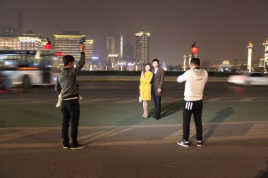 Xi'an, Shaanxi, China - March 18, 2017: Couple of models posing and presenting newest fashion trends in front of Xi'an skyline.  clipart