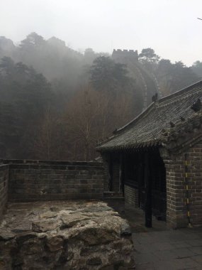 Huairou, Beijing, China - March 20, 2017: Section of Mutianyu Great Wall of China on a rainy day in mystical wafts of mist. clipart