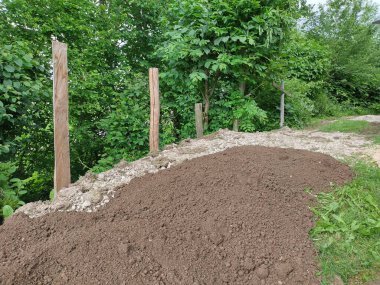 Freshly dumped, evenly distributed humus soil at gravel in park in Austria, Europe. Renaturation of former asphalt. Ecological restoration. Ecosystem restoration. Assisting recovery of ecosysystem. clipart