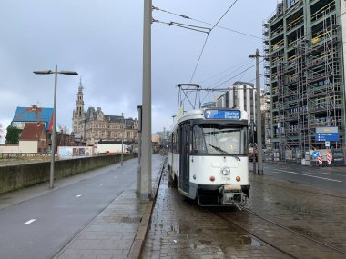 Antwerp, Flanders, Belçika - 09 Ocak 2025: Tramvay tipi BN PCC Antwerpen, istasyon yedinci hat, arka planda güzel Loodswezen binası.