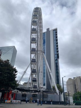 Atlanta, GA, USA - September 28, 2024: View of giant ferris wheel in downtown Atlanta, Georgia in Centennial Olympic Park. The SkyView Ferris Wheel features 42 gondolas. Cloudy day in fall. Vertical clipart