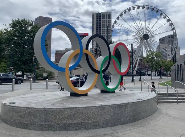 Atlanta, GA, ABD - 28 Eylül 2024: Atlanta şehir merkezindeki Centennial Olimpiyat Parkı 'nda Olimpiyat Halkaları, SkyView Atlanta, arka planda taşınabilir dönme dolap. Bulutlu bir günde gezmek.