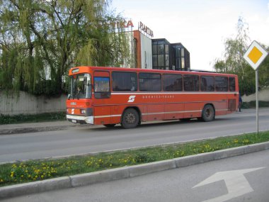 Pristina, Kosovo - April 21, 2006: Aged coach with former logo and in orange color of Austrian Federal Railways BB, donated from Austria's government to post-war Kosovo. Operated by Drenica-Trans. clipart