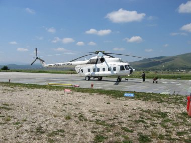 Pristina, Kosovo - June 01, 2006: Heli pad of United Nations Interim Administration Mission in Kosovo at Prishtina International Airport with Mil Mi-8P heli in white UN livery. clipart