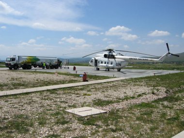 Priştine, Kosova - 01 Haziran 2006: BM 'nin Kosova' daki Birleşmiş Milletler Geçici Yönetim Misyonunun yürüttüğü beyaz üniformalı Mil Mi-8P helikopteri Prishtina Uluslararası Havaalanı helikopter pistinde yakıt ikmali yapmak üzere.